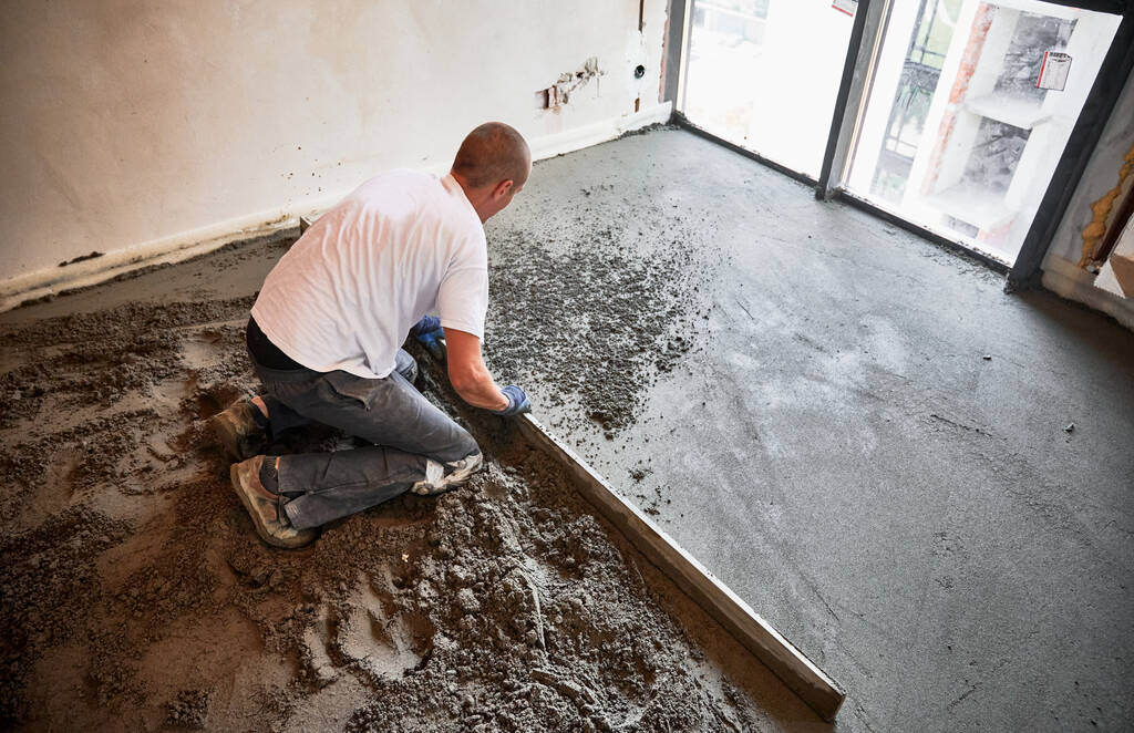 afw construction-worker-using-screed-rail-while-screeding-floor-living